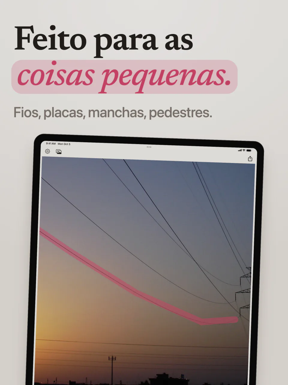 O Mend no iPad com um traço rosa ao longo de um fio de energia que cruza o céu do entardecer